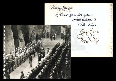 Harry Lange Auction | Black and White Behind the Scenes Still of Medal Award Ceremony Featuring Thank You Note to Harry Lange On the Back - Signed by George Lucas and Gary Kurtz | Propstore
