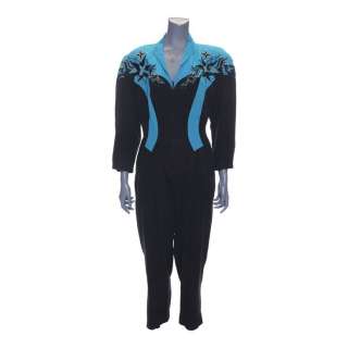 The Goldbergs | Beverly Goldberg’s (as played by Wendi McLendon-Covey) "Push It" Black and Blue Jumpsuit with "B" Necklace | Propstore