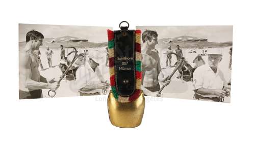 JAMES BOND: ON HER MAJESTY‘S SECRET SERVICE (1969) - Lot 384 - Crew Gift Cowbell and Two Black-and-white On-set Photographs